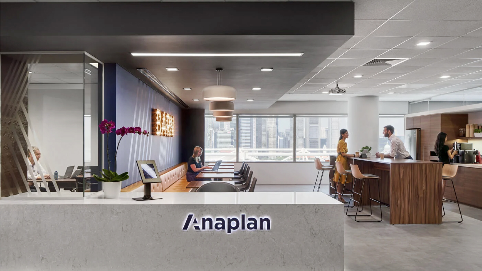 Anaplan Careers Be Developed Resource Tile Image of Anaplan employees in one of our office spaces talking, working on laptops, and grabbing coffee