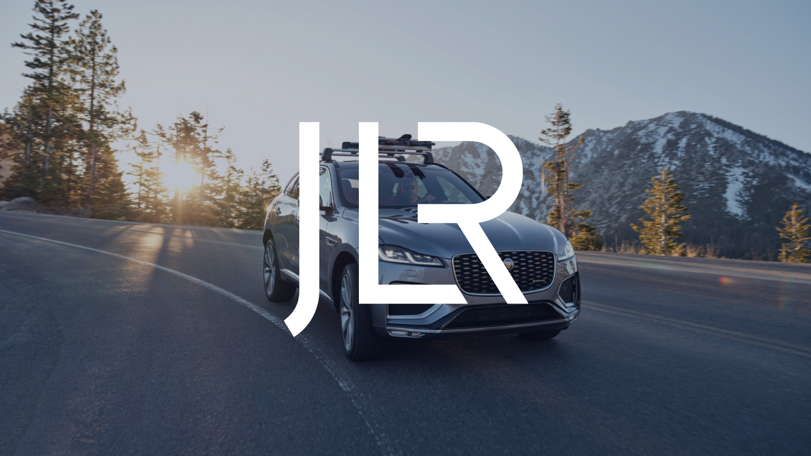 JLR Graphic: JLR logo over Jaguar SUV driving on an open road