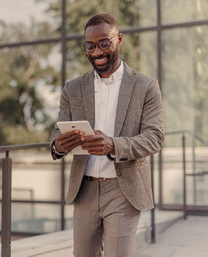 HR Workforce Solutions Overview Image A man in a suit and glasses stands on a sidewalk next to a glass rail, exuding professionalism and confidence.