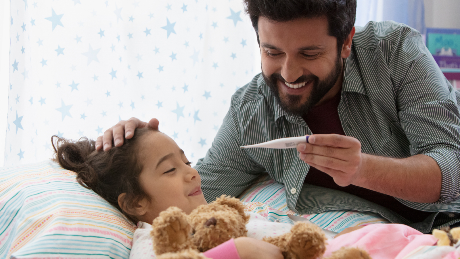 resources-customer-story-images-bayer-consumer-health Dad rubbing daughters head while looking at a thermometer